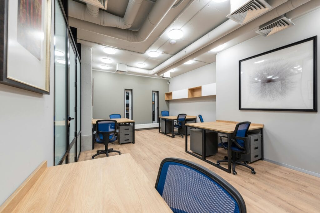 Essential Guide to Air Duct Maintenance 1 Contemporary office interior with desks, chairs, and abstract art. Ideal for business settings.
