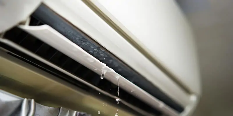 Factors Influencing AC Leak Repair Expenses 1 AC Leak Repair Expenses explained with a technician inspecting an air conditioning system for refrigerant leaks and repair costs